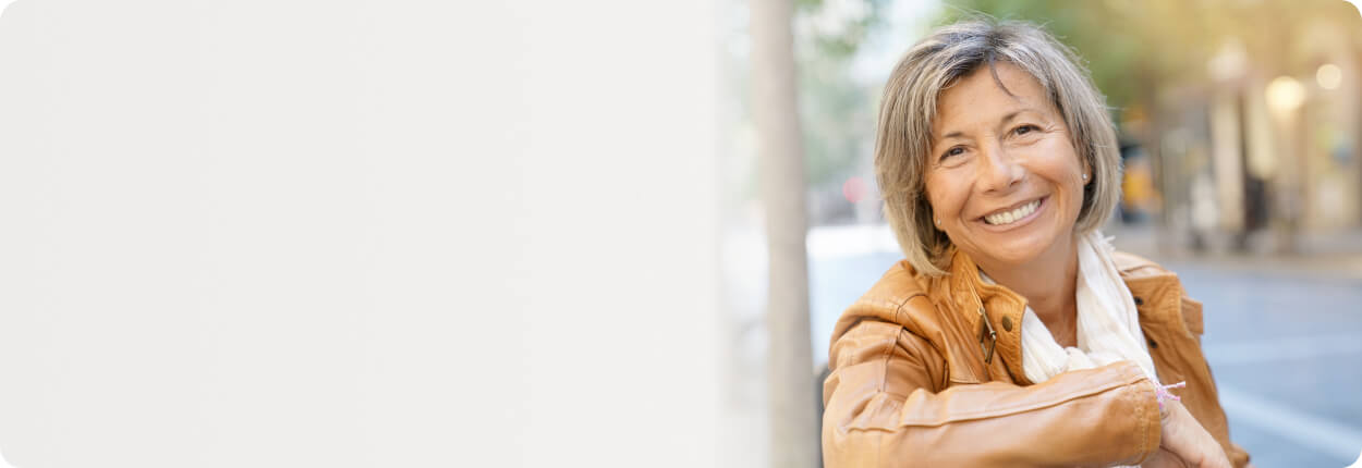 Smiling woman outside sitting on a bench