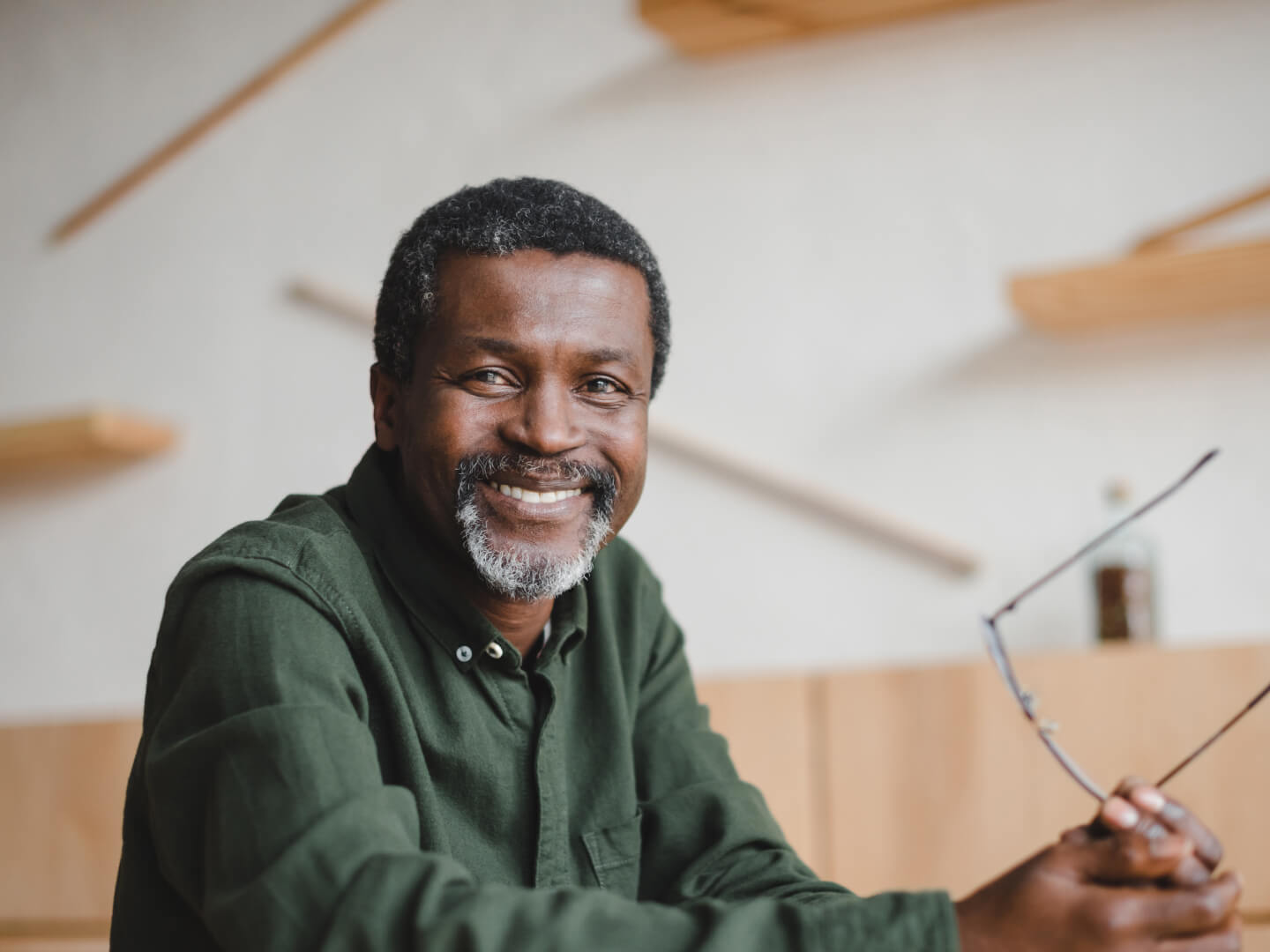 Smiling older man holding glasses